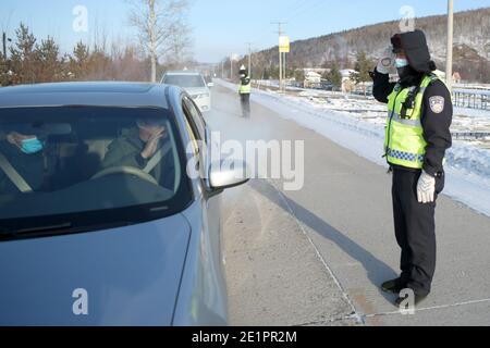 Dahinggan, Chinas Provinz Heilongjiang. Januar 2021. Verkehrspolizist Sun Chen überprüft Fahrzeuge auf einer Straße im Bezirk Huzhong in Dahinggan, nordöstlich der Provinz Heilongjiang, 8. Januar 2021. Sun Chen ist seit 35 Jahren Verkehrspolizist. Im Bezirk Huzhong, genannt "die kälteste Stadt Chinas", klebte Sun an seinem Posten, um die Verkehrsordnung aufrechtzuerhalten. Trotz des extrem kalten Wetters mit der niedrigsten Temperatur von etwa minus 40 Grad Celsius nahm er früh am Morgen seine Schicht auf. Quelle: Wang Jianwei/Xinhua/Alamy Live News Stockfoto