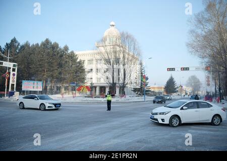 Dahinggan, Chinas Provinz Heilongjiang. Januar 2021. Verkehrspolizist Sun Chen leitet den Verkehr an einer Kreuzung im Bezirk Huzhong in Dahinggan, nordöstlich der Provinz Heilongjiang, 8. Januar 2021. Sun Chen ist seit 35 Jahren Verkehrspolizist. Im Bezirk Huzhong, genannt "die kälteste Stadt Chinas", klebte Sun an seinem Posten, um die Verkehrsordnung aufrechtzuerhalten. Trotz des extrem kalten Wetters mit der niedrigsten Temperatur von etwa minus 40 Grad Celsius nahm er früh am Morgen seine Schicht auf. Quelle: Wang Jianwei/Xinhua/Alamy Live News Stockfoto