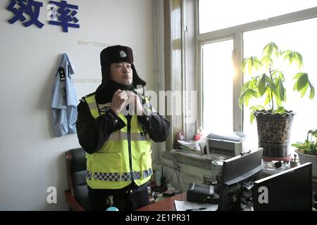 Dahinggan, Chinas Provinz Heilongjiang. Januar 2021. Verkehrspolizist Sun Chen macht sich bereit für den Dienst in seinem Büro im Bezirk Huzhong in Dahinggan, nordöstlich Chinas Provinz Heilongjiang, 8. Januar 2021. Sun Chen ist seit 35 Jahren Verkehrspolizist. Im Bezirk Huzhong, genannt "die kälteste Stadt Chinas", klebte Sun an seinem Posten, um die Verkehrsordnung aufrechtzuerhalten. Trotz des extrem kalten Wetters mit der niedrigsten Temperatur von etwa minus 40 Grad Celsius nahm er früh am Morgen seine Schicht auf. Quelle: Wang Jianwei/Xinhua/Alamy Live News Stockfoto