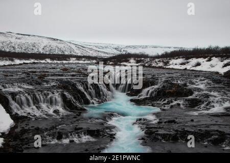 Leuchtend blau türkis Wasserfall Stromschnellen Kaskaden vulkanischen Felsen Spalt Bruarfoss Bruara Fluss in Brekkuskogur Golden Circle Island Europa Stockfoto