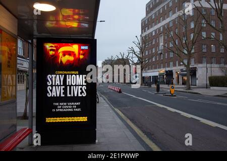 'Stay Home, save lives' - Beschilderung auf einem Bus Tierheim in London als Coronavirus Fälle in Großbritannien sind grassierend. Stockfoto