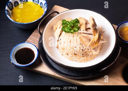 Asian Food Concept Hainanese Chicken Rice mit sauer und süß sojasauce auf Holzbrett mit Schieferstein Hintergrund Stockfoto