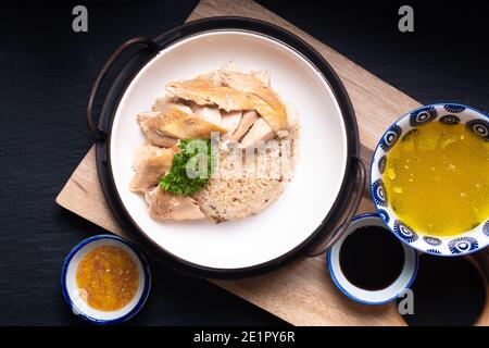 Asian Food Concept Hainanese Chicken Rice mit sauer und süß sojasauce auf Holzbrett mit Schieferstein Hintergrund Stockfoto