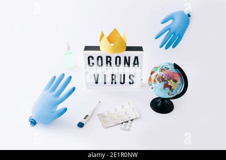 Covid-19 Globale Pandemie des Corona-Virus. Lightbox mit Text, Handschuhen Ballons und Globus auf hellem Hintergrund. Stockfoto