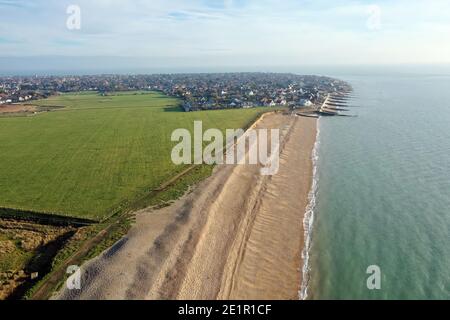 Luftaufnahme entlang eines breiten Strandes von Medmerry, mit Blick auf die Stadt Selsey in West Sussex. Stockfoto