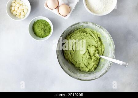 Roher Teig mit Matcha grüner Tee in Metallschüssel Stockfoto