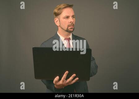 Blond bärtigen Geschäftsmann mit Spitzbart gegen grauer Hintergrund Stockfoto