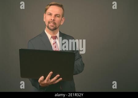 Blond bärtigen Geschäftsmann mit Spitzbart gegen grauer Hintergrund Stockfoto