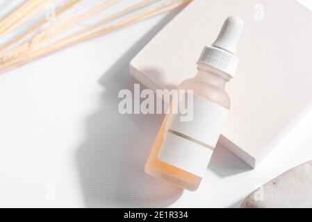 Nahaufnahme gelbe Serum Essenz in Glasflasche auf weißem Standhintergrund. Isoliertes Hautpflegeöl Stockfoto