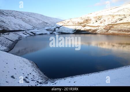 Reflexionen im Upper Ogden Reservoir von der Staumauer im Winter in der Nähe des Dorfes Gerste auf dem Weg zum Pendle Hill in Ogden Clough, Lancashire. VEREINIGTES KÖNIGREICH. Stockfoto