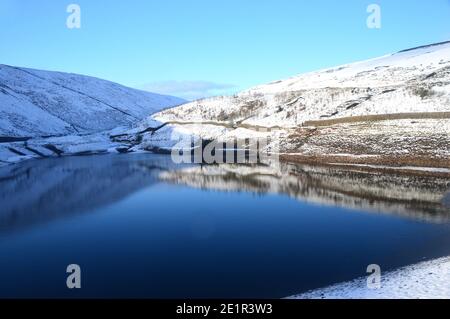 Reflexionen im Upper Ogden Reservoir von der Staumauer im Winter in der Nähe des Dorfes Gerste auf dem Weg zum Pendle Hill in Ogden Clough, Lancashire. VEREINIGTES KÖNIGREICH. Stockfoto