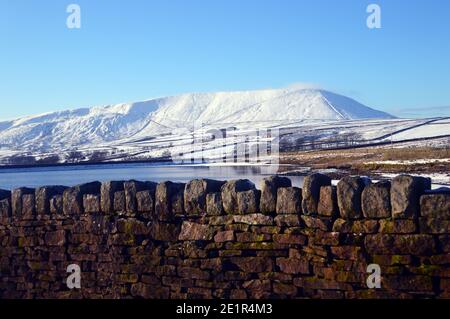 Dry Stone Wall & Pendle Hill vom Upper Black Moss Reservoir im Winter in der Nähe des Dorfes Gerste, Pendle, Lancashire. VEREINIGTES KÖNIGREICH. Stockfoto