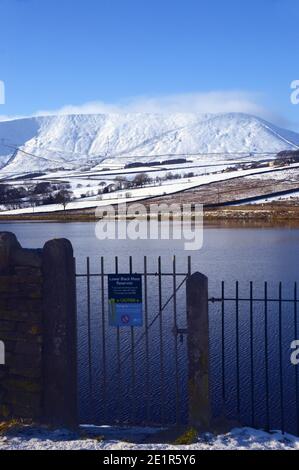 Trockensteinmauer/Iron Gate und Pendle Hill vom Lower Black Moss Reservoir im Winter in der Nähe des Dorfes Gerste, Pendle, Lancashire. VEREINIGTES KÖNIGREICH. Stockfoto