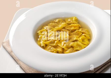 Ravioli del Plin in Brühe, typisch piemontesische gefüllte Pasta aus der Langhe, Italien, in weißem Teller Stockfoto