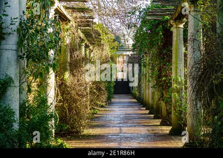 Steinsäulen flankieren einen Ziegelweg. Teil von Hampstead Pergola auf der Heide. Stockfoto