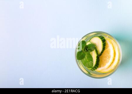 Sauges Wasser für die Entgiftung mit Zitrone, Gurke und Minze in Glas auf hellblauem Hintergrund infundiert. Draufsicht. Gesundes Lifestyle-Konzept. Leerzeichen für Text. Stockfoto