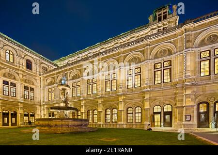 Seitenansicht und Brunnen der Wiener Staatsoper bei Nacht in Österreich. Stockfoto