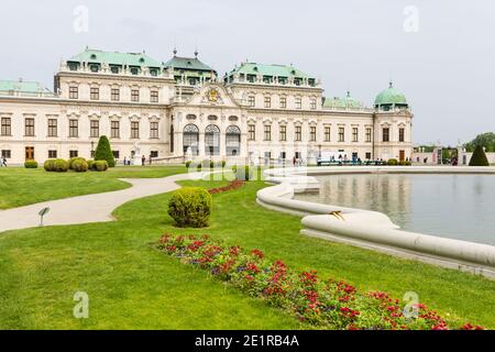 Blick auf das Obere Belvedere im Schlosspark Belvedere von Wien, Österreich mit einigen Touristen im Garten und einem Teich rechts. Stockfoto