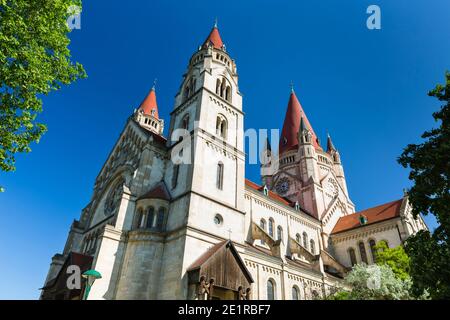 Tiefer Blick auf die schöne St. Franz von Assisi Kirche in Wien, Österreich mit tiefblauem Himmel. Stockfoto