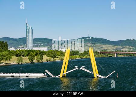 Die Ponte Cagrana Brücke über die Donau in Wien, Österreich mit Kahlenberg und Millennium Tower im Hintergrund. Stockfoto