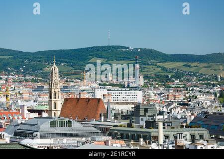 Blick von einem Kirchturm über die Wiener Innenstadt mit dem Turm der Müllverbrennungsanlage Spittelau und dem Kahlenberg im Hintergrund, Stockfoto