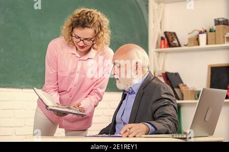 Bitte helft mir. Schüler, der Lehrer nach Aufgabe fragt. Erzieher und Schüler beim Betragen des Buches. Erläuterung schwieriger Informationen. Lösung mathematischer Aufgaben. Buch Quellwissen. Schulbuch Konzept. Hausaufgaben überprüfen. Stockfoto