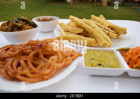 Spezielle gujarati Küche für Uttarayan Festival. Verschiedene Gerichte wie Fafda, Jalebi, Undhiyu, roher Papaya-Salat, authentischer gujarat spezielle Snack-Artikel Stockfoto