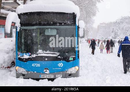 Madrid, Spanien. Januar 2021. Aufgrund des Schneefalls, der durch den Sturm von Filomena verursacht wurde, wurden die Straßen und Straßen mit Schnee bedeckt, sodass ein Bus gefangen blieb, während die Menschen den Schnee in der Mitte der Straße genießen. Álvaro Laguna/Alamy Live News Stockfoto