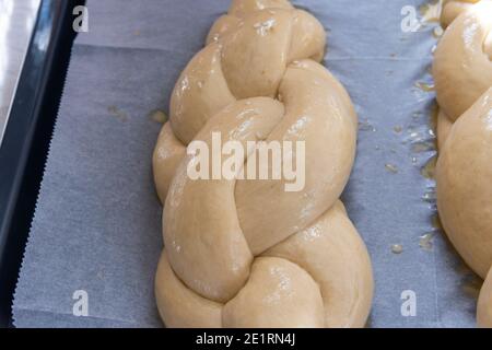 Hausgemachtes Challah-Brot backen. Vor dem Backen in einer Pfanne mit Sesamsamen umflechten. Der Teig puffte vor dem Backen. Hochwertige Fotos Stockfoto