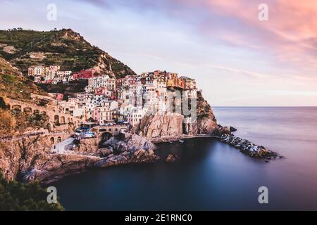 ITALIEN, SONNENUNTERGANG IN MANAROLA: Manarola, Weiler von Riomaggiore, ist ein städtebauliches Juwel, reich wie es in typischen Hochhäusern des genovesischen Stils ist. Das Dorf wurde im XII Jahrhundert gegründet und hat seinen Namen wahrscheinlich von einer antiken "Magna roea", einem großen Mühlrad, das im Dorf vorhanden ist, abgeleitet. Stockfoto