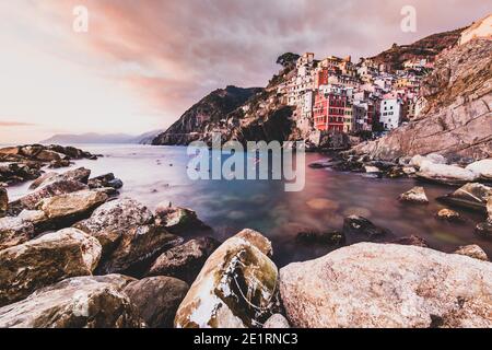 ITALIEN, SONNENUNTERGANG IN RIOMAGGIORE: Wir haben die ersten Nachrichten von Riomaggiore erst im Jahr 1251, als die Bewohner des Bezirks von Carpena, Küste verbreiten, geschworen Glauben an die Republik von Genua. Zwischen 1200 und 1300 beschlossen die Bewohner dieser Siedlungen, zum Meer hinabzugehen und dem Dorf Leben zu schenken. Eine Bewegung, die durch die Konsolidierung der genovesischen Herrschaft begünstigt wurde, die einem ruhigeren Zugang zum Meer zustimmte, auf dem sich der Handel schnell und sicher entwickeln konnte. Stockfoto