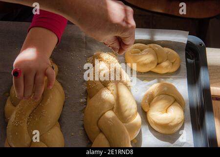 Hausgemachtes Challah-Brot backen. Vor dem Backen in einer Pfanne mit Sesamsamen umflechten. Der Teig puffte vor dem Backen. Hochwertige Fotos Stockfoto