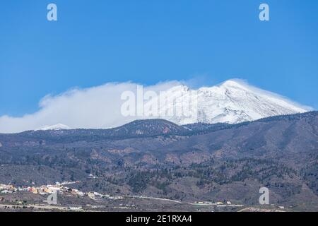 Teneriffa, Kanarische Inseln, Spanien. Januar 2021. Der Berg Teide und der Pico Viejo sind schneebedeckt von Playa San Juan an der Westküste mit einem klaren blauen Himmel. Sturm Filomena hat in den letzten Tagen bis zu 62 Liter Niederschlag pro Quadratmeter und schwere Schneefälle in die höheren Bergregionen gebracht. Stockfoto