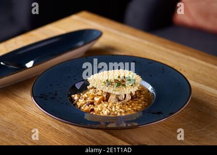 Italienische Küche, Risotto aus Reis und Pilzen auf dem Tisch, serviert in einem Restaurant, Menü Food-Konzept. Stockfoto