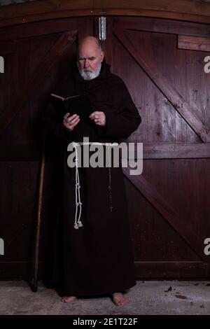 Franziskanermönch, barfuß, liest seine bibel. Stockfoto