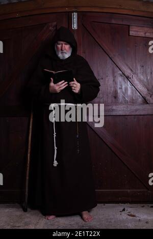 Franziskanermönch, barfuß, liest seine bibel. Stockfoto