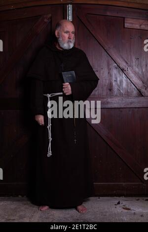 Franziskanermönch, barfuß, mit seiner bibel. Stockfoto