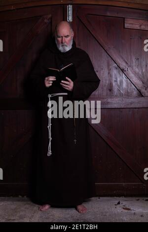 Franziskanermönch, barfuß, liest seine bibel. Stockfoto