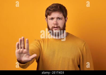 Besorgt seriöse bärtige Mann in runden Brillen zieht Handfläche in Richtung Kamera, stoppt oder warnt Sie vor schlechter Wahl, zeigt genug oder Ablehnung Geste Stockfoto
