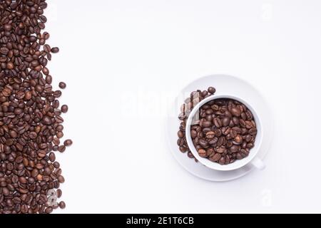 Draufsicht auf weiße Tasse gefüllt mit frisch geröstetem Kaffee Bohnen isoliert auf weißem Hintergrund Stockfoto
