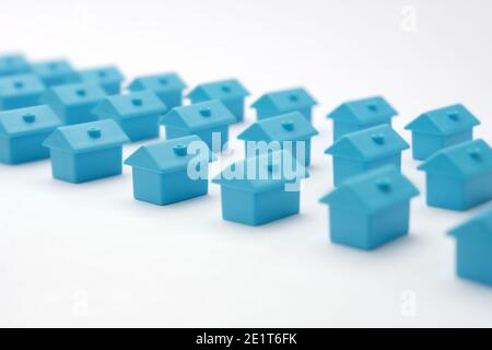 Immobilien in Cottage Village. Hauseigentümervereinigung. Reihen Spielzeughäuser. Blaue Miniaturhäuser in drei Reihen angeordnet. Miniatur-Spielzeuggebäude. Viele Stockfoto