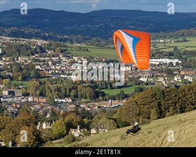 Gleitschirmfliegen von Selsley Hill, mit Selsley Village und Stroud im Hintergrund, Gloucestershire, UK, Oktober. Stockfoto