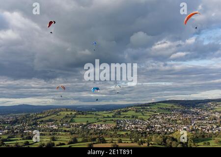 Gleitschirme fliegen von Selsley Hill, mit Stroud und Gloucester im Hintergrund, Gloucestershire, UK, Oktober. Stockfoto