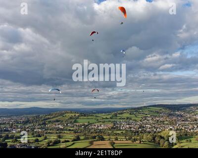 Gleitschirme fliegen von Selsley Hill, mit Stroud und Gloucester im Hintergrund, Gloucestershire, UK, Oktober. Stockfoto