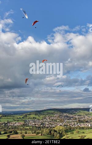 Gleitschirme fliegen von Selsley Hill, mit Stroud und Gloucester im Hintergrund, Gloucestershire, UK, Oktober. Stockfoto