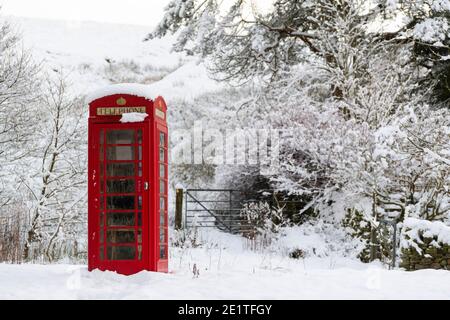 Kirkby Stephen, Cumbria, Großbritannien. Januar 2020. Eine rote Telefondose ragt im Schnee in einer abgelegenen ländlichen Gemeinde, Outhgill, in Mallerstang bei Kirkby Stephen im Eden Valley, Cumbria, hervor. Es wird nicht mehr als Telefonbox verwendet, sondern als Community-Hub mit Newslettern und lokalen Informationen genutzt. Quelle: Wayne HUTCHINSON/Alamy Live News Stockfoto