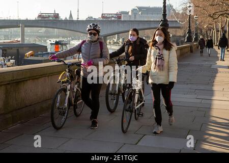 London, Großbritannien. Januar 2021. Menschen mit Gesichtsmasken als vorbeugende Maßnahme gegen die Ausbreitung von covid19 Spaziergang entlang der Embankment Bridge. Quelle: Pietro Recchia/SOPA Images/ZUMA Wire/Alamy Live News Stockfoto