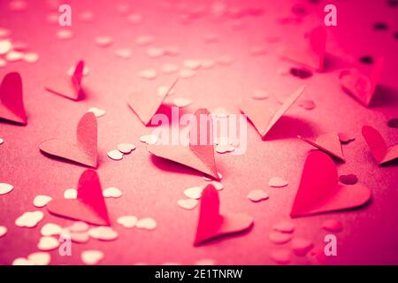 Rote Papierherzen auf rotem Hintergrund als Hintergrund. Konzept der Liebe und Valentine Stockfoto