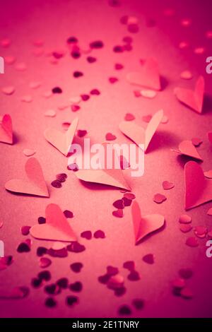 Rote Papierherzen auf rotem Hintergrund als Hintergrund. Konzept der Liebe und Valentine Stockfoto