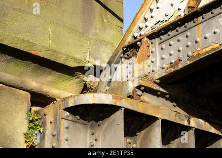 Unkraut wächst auf einem Eisenträger und Stein Eisenbahnbrücke Details Stockfoto